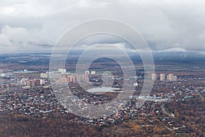 A small city from the height of the aircraft. High-rise buildings near the lake. View of the earth from an airplane.