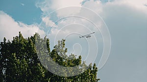 A small civilian helicopter flies low above the ground.