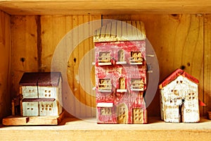 Small clay house model in woodshelf interior decorate