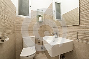 Small cloakroom with white porcelain sink, frameless mirror