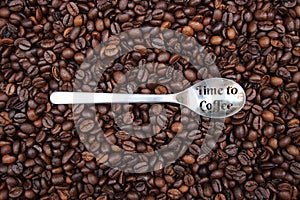 Background with many coffee beans and metal spoon photo