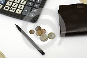 Small coins wallet calculator and fountain pen on sheets of white paper on the table concept business budget economy