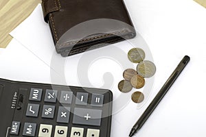 Small coins wallet calculator and fountain pen on sheets of white paper on the table concept business budget economy