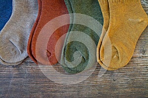 Small colorful baby socks on wooden background