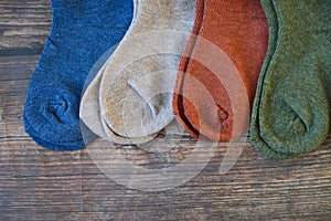 Small colorful baby socks on wooden background