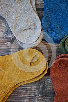 Small colorful baby socks on wooden background