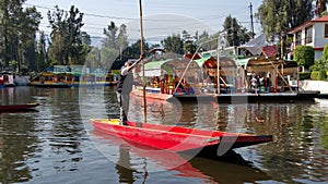 Small, colorful boat being poled at Xochimilco