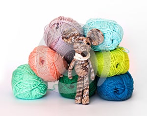 Small colorful knitted toy mouse in a white scarf