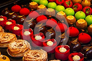 Small colorfull cakes with different stuffing on a showcase in shop