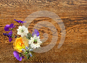 Small colourful posy of flowers on a wooden table.