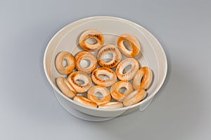 Small cookies ring shaped sushki in bowl on gray background