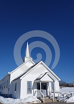 Small country New England church in snowy field