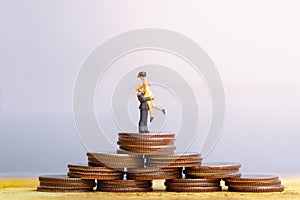 Small couple figures in love standing on stack of coins. Love and Valentine`s day concepts.