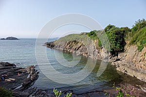 Small cove in the Atlantic ocean located in La Coruna, Spain. With bathers on the rocks