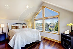 Small and cozy bedroom with nightstand, hardwood floor and vaul