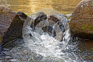 Small creek with clear waters running through the rocks