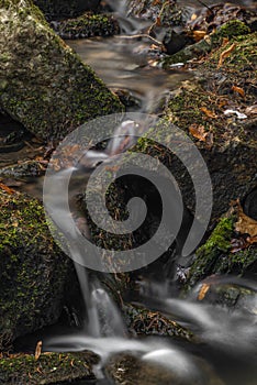 Small creek near Zlata Koruna village with green moss stone in winter cold day