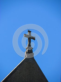 A small cross on top of an old convent