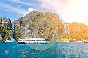 Small cruise ship in the waters of andaman sea with rocky island on background. At sunny day