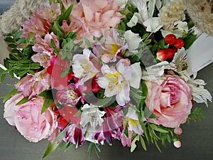 Flowers cute bouquet with roses and alstroemerias pink white green, wooden box photo