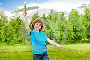 Small cute boy holds white airplane toy alone