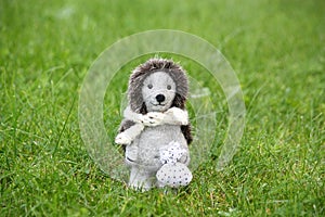 Small cute felt hedhehog standing in the grass