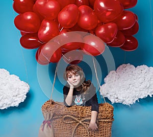 Small cute girl flying on red heart balloons Valentines day