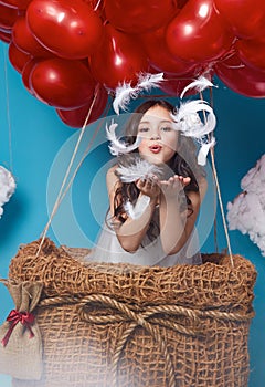 Small cute girl flying on red heart balloons Valentines day