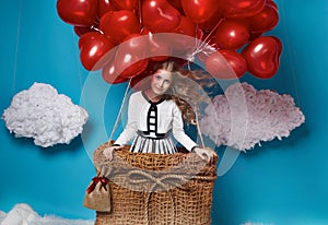 Small cute girl flying on red heart balloons Valentines day