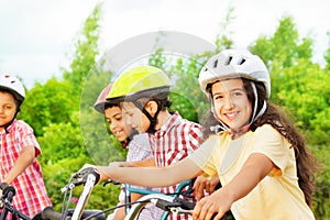 Small cute girl in helmet holds bike handle-bar photo