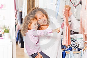 Small cute girl with her mother choosing dress