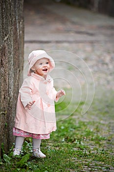 Small cute girl standing near old wall