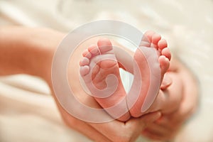 The Small Cute Soles of Newborn Feets are in the Father's Hands.