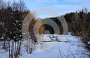 Small dam on a frozen river in the middle of the forest.