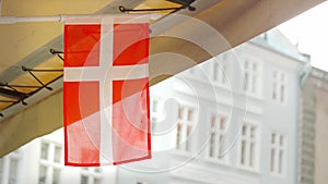 Small Danish flag waving in the wind and rain