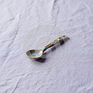 A small, decorative ceramic spoon rests
