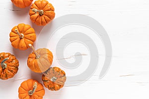 Small decorative pumpkins on white wooden background. Autumn, fall, thanksgiving or halloween day concept, flat lay, top view