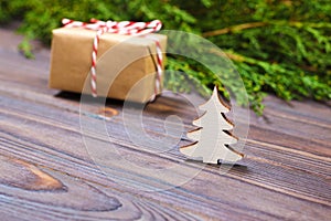 Small decorative white wooden christmas tree and gift with red ribbon New Year concept, gift from kraft paper