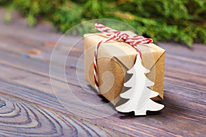 Small decorative white wooden christmas tree and gift with red ribbon New Year concept, gift from kraft paper