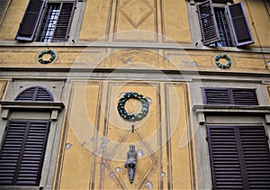 Small detail with colored crowns, with three windows and a door, of the wall, overlooking the park, near the entrance, of the beau