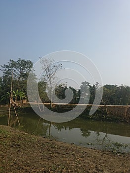 Small ditch,road,sky,trees are include in this picture is so preety & nice.