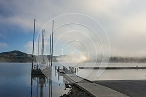 Small dock and barge by lake.