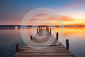 Small Dock or wooden pier and the sea lake at sunset