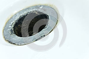 Small DOF. Damaged sewer hole with corrosion elements in a white bath, washbasin or shower. Water destroys everything. Concept on