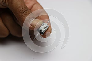 Small dual shaft dc motor held in hand. Micro dc motor with 2 shafts use to make electronic projects such as small robots and cars