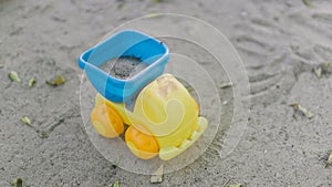 Small dump truck empties sand. Miniature. Children play in the sand photo
