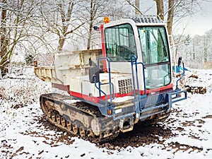 Small Dumper Tracked Truck with Muddy Chassis. The transporter waiting