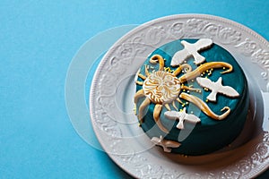 Small easter blue cake with yellow sun and white doves in the white plate. Blue background.