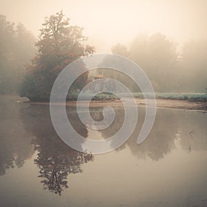 Small eastern arbour on a lake island in fog