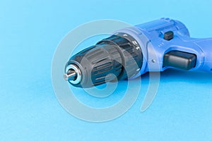 A small electric screwdriver screwdriver on a blue background